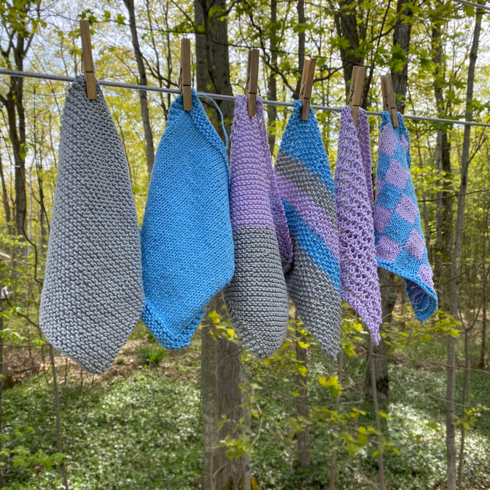 set of the knitted dishcloths hanging on a clothes line