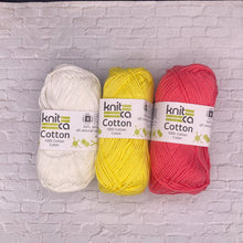 Load image into Gallery viewer, Three balls of yarn in white, yellow, and pink with &#39;Knitca Cotton&#39; labels on a light gray brick background.