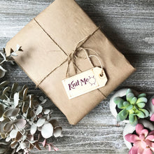 Load image into Gallery viewer, Picture of a package wrapped up with brown paper and string representing the Wonderland subscription box
