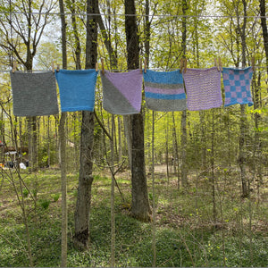 set of the knitted dishcloths hanging on a clothes line